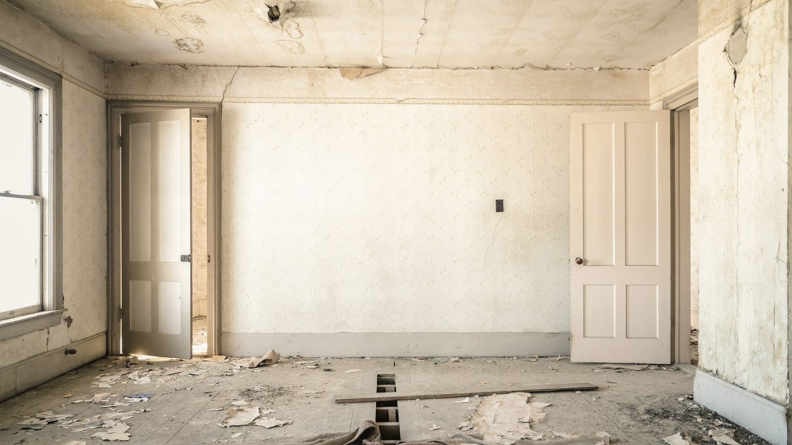 Séjour avant rénovation : papier peint abîmé, plancher dégradé