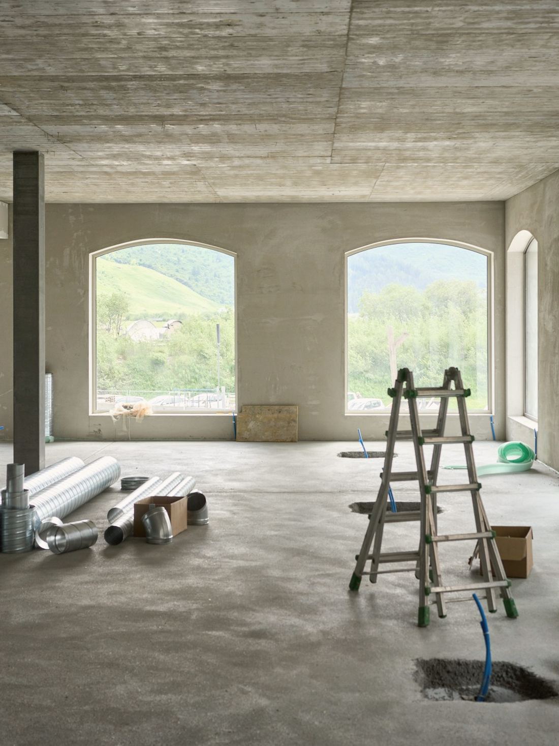 Plateau en rénovation, fenêtres cintrées et échelle, matériaux prêts à poser